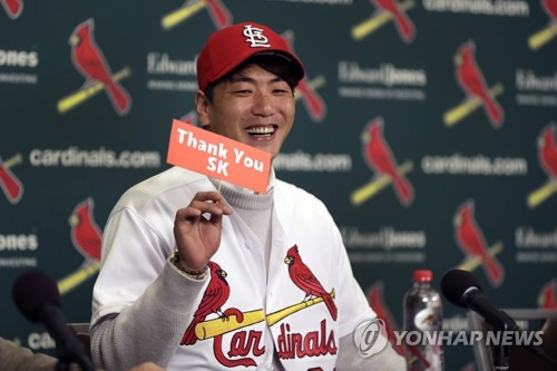 SK에 감사 표하는 MLB 세인트루이스  김광현 대한민국 좌완 에이스 김광현이 2019년 12월 17일(현지시간) 미국 미주리 주 세인트루이스에서 열린 미국프로야구 메이저리그(MLB) 세인트루이스 카디널스 입단 기자회견 중 그의 전 소속팀 SK 와이번스에 감사를 표하는 플래카드를 든 채 미소짓고 있다. [AP=연합뉴스 자료사진]