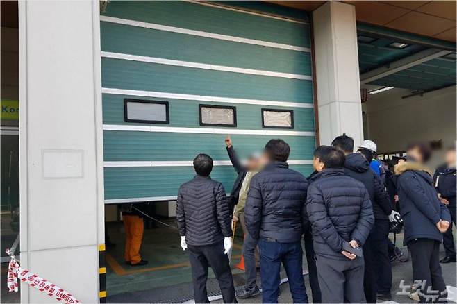 지난 2일 부산 사하소방서 다대119안전센터에서 열린 국과수 현장감식에서 관계자들이 추락한 셔터를 살펴보고 있다. (사진=부산CBS 박진홍 기자)