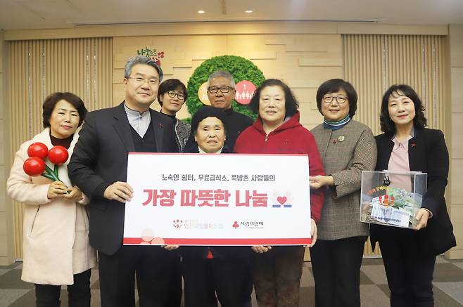 이준모 인천내일을여는집 이사장(왼쪽 두 번째)과 김연순 사랑의열매 사무총장(오른쪽 두 번째)이 인천 쪽방 주민 대표 김정남씨(앞줄 왼쪽 세 번째)를 포함한 관계자들과 함께 기념촬영을 하고 있다. © 뉴스1