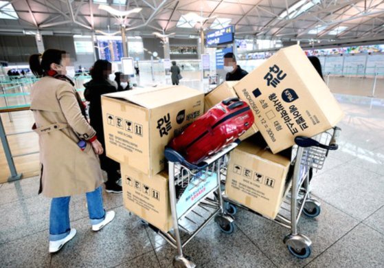 3일 오후 인천국제공항 1터미널에서 중국인 여행객들이 마스크 박스가 실린 카트를 밀고 탑승수속대로 향하고 있다. [연합뉴스]