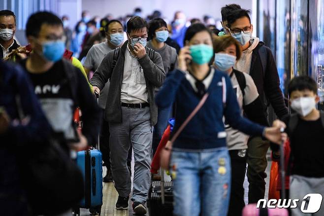 3일 중국 선전에서 홍콩 MTR 로우역에 마스크를 쓴 사람들이 도착하고 있다. 홍콩 정부는 이후 선전만 검문소와 강주아오 대교 2곳을 빼고 중국과의 국경을 폐쇄했다. © AFP=뉴스1