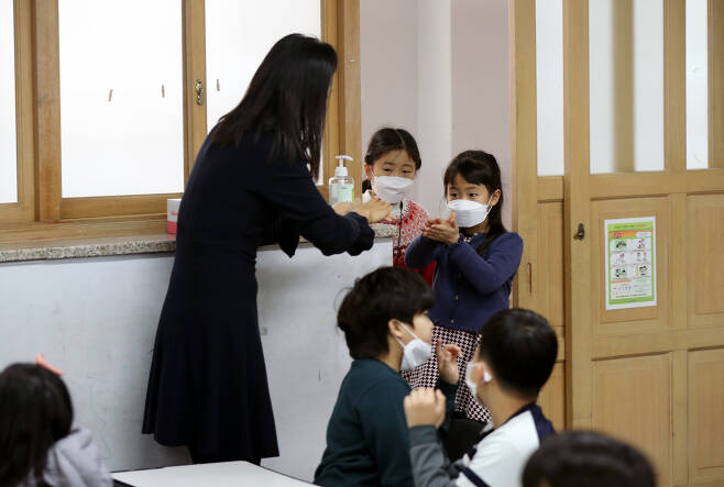 지난 3일 개학한 부산 부산진구 양정초등학교에서 어린이들이 신종 코로나바이러스 감염증 예방을 위해 세정제로 손을 씻고 교실로 들어오고 있다. [연합]