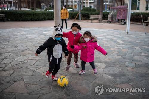 지난달 29일 중국 베이징에서 마스크를 착용한 채 공을 차는 아이들 [AFP=연합뉴스]