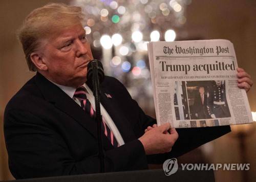 탄핵심판 무죄 결정 내용이 1면에 실린 워싱턴포스트를 들어보이는 도널드 트럼프 미국 대통령 [AFP=연합뉴스]