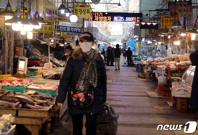 7일 오후 광주 서구 양동시장에서 한 시민이 마스크를 쓰고 지나가고 있다.2020.2.7/뉴스1© 뉴스1