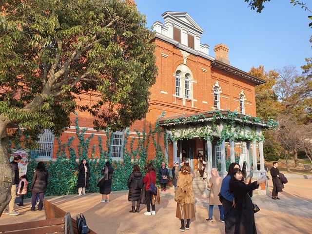 TV드라마 ‘호텔 델루나’ 촬영지로 유명한 목포근대역사관(구 일본 영사관) 앞에서 관광객들이 기념촬영을 하고 있다.