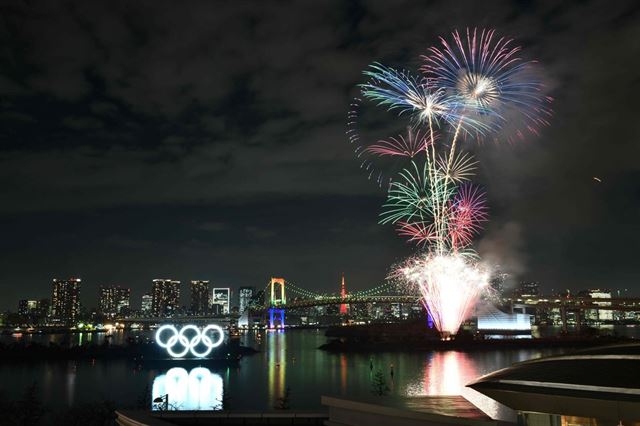 지난달 24일 도쿄 오다이바 해양공원에서 도쿄올림픽 개막이 6개월 앞으로 다가온 것을 기념하기 위한 불꽃놀이 행사가 벌어지고 있다. 도쿄=AFP 연합뉴스