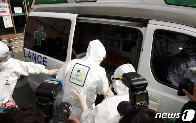 21일 오전 청도대남병원 코로나19 확진자 중 1명이 부산대병원으로 이송되기 위해 방역복을 입고 방역당국의 안내를 받아 청도군보건소 앰블런스로 이동하고 있다.2020.2.21/뉴스1  <저작권자 ⓒ 뉴스1코리아, 무단전재 및 재배포 금지>