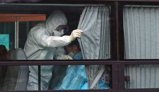 27일 오후 경북 청도대남병원에서 서울 국립정신건강센터로 이동하는 환자 이송 버스 안에서 한 의료진이 커튼을 치고 있다. 연합뉴스