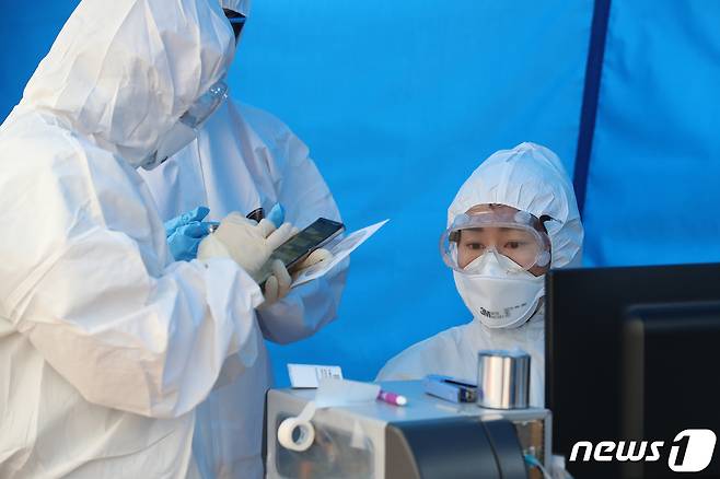 신종 코로나바이러스 감염증(코로나19) 확산이 거듭되는 28일 대구 달서구 계명대학교 동산병원 선별진료소에서 의료진이 코로나19 증상을 호소하며 방문한 시민들에 대해 상담과 검사를 진행하고 있다. 코로나19 유증자로 분류한 신천지예수회(이하 신천지) 신도가 28일 기준 총 3000여명에 육박하는 것으로 나타났다./뉴스1 © News1 공정식 기자