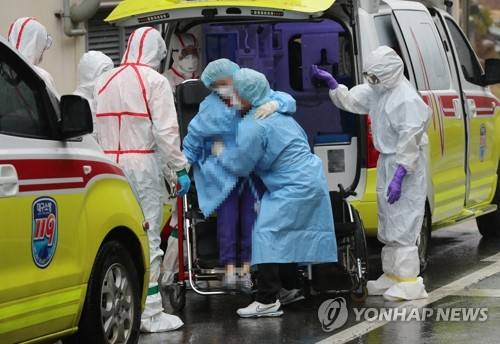 자녀 껴안아 옮기는 확진자 가족 (광주=연합뉴스) 박철홍 기자 = 7일 오후 광주 남구 빛고을전남대병원에서 코로나19 확진자가 거동이 불편한 자녀를 직접 안아 옮기고 있다. 2020.3.7 pch80@yna.co.kr