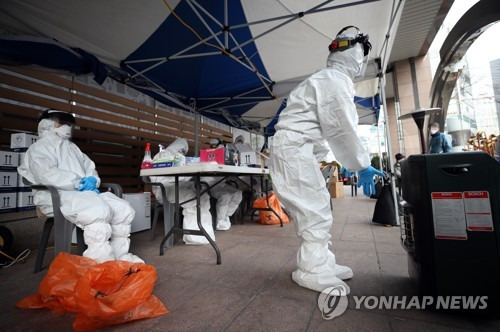 시린 손 녹이며 (서울=연합뉴스) 박동주 기자 = 12일 오전 코로나19 확진자가 무더기로 발생한 서울 구로구 신도림동 코리아빌딩 앞 선별진료소에서 관계자들이 검사 준비를 하며 시린 손을 난로에 녹여보고 있다.  pdj6635@yna.co.kr