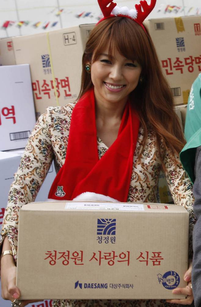 2009년 '나눌수록 맛있는 행복'이라는 주제로 열린 연말 연시, 결손 가정 아동 돕기 행사에서 선물 세트를 운반하는 이효리  <사진=연합뉴스>