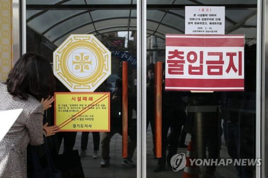 지난달 24일 경기도 성남시온교회에서 담당 공무원이 '신천지 집회 전면금지 및 시설 강제폐쇄 경기도 긴급행정명령' 시행에 따라 폐쇄 안내문을 부착하고 있다. [이미지출처=연합뉴스]