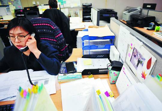 조은희씨가 지난 19일 서울 강서구 김포공항 화물청사에 있는 회사에서 업무를 하고 있다. 책상 한켠에 아이들 사진이 놓여 있다.