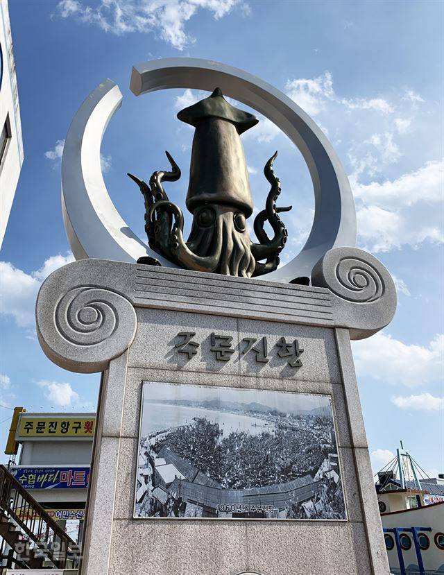 주문진항 상징탑에 붙어 있는 1960년대 항구 사진. ‘라떼는 말이야’로 시작하는 전설이 줄줄이 엮여 나올 풍경이다.