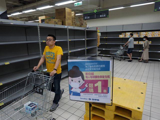 대만 북부 뉴타이페이시의 한 슈퍼마켓에서 21일 한 고객이 텅 빈 휴지 진열대 앞을 지나가고 있다.  뉴타이페이=EPA 연합뉴스