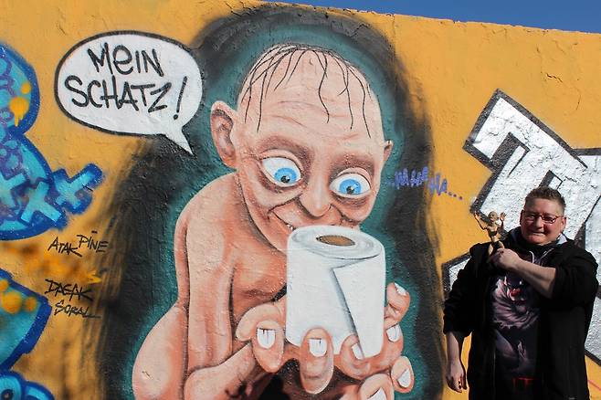 베를린 마우어파크의 '화장지 사재기' 풍자 골룸 그라피티 앞에 골룸 미니어처를 갖고 나온 시민 [베를린=연합뉴스]