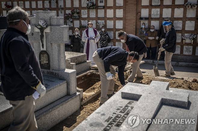 지난 28일 스페인 마드리드의 한 묘지에서 코로나19로 사망한 노인의 시신이 안장되고 있다. [AP=연합뉴스]