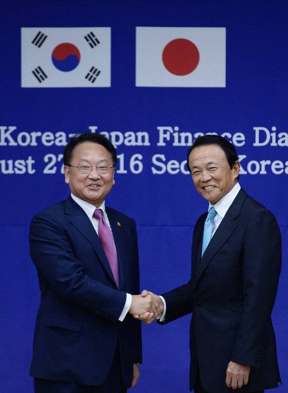 2016년 8월 당시 유일호(왼쪽) 경제부총리 겸 기획재정부 장관과 아소 다로 일본 부총리 겸 재무상이 정부서울청사에서 양국의 경제협력 방안을 논의하기 위한 제7차 한일 재무장관회의에 참석해 악수하고 있다. [뉴시스]