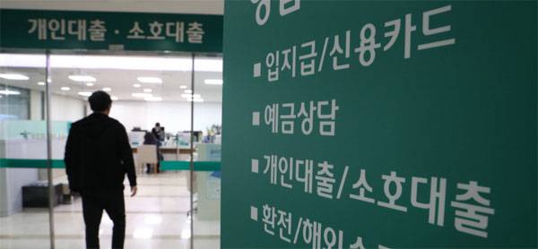 정부가 코로나19 피해 지원을 위해 소상공인·중소기업에 이어 가계에도 대출 만기를 연장하고 이자 상환을 유예하는 방안을 곧 발표할 예정이다. 한 고객이 대출 상담을 받기 위해 은행 창구에 들어서고 있다. [매경 DB]