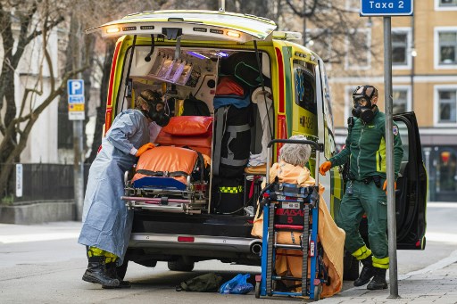 보호용 방독면을 쓴 구급대원들이 4월 6일(현지시간) 스웨덴 스톡홀름에서 코로나19 환자의 이송을 돕고 있다./사진=AFP