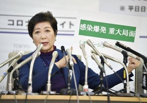 (도쿄 교도=연합뉴스) 고이케 유리코 일본 도쿄도 지사가 3월 25일 오후 도쿄도청에서 긴급 기자회견을 하던 중 '감염폭발 중대국면'이라고 쓴 카드를 들어 보이고 있다.