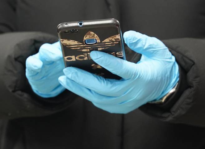 장갑을 끼고 휴대전화를 사용하는 모습. [연합뉴스]