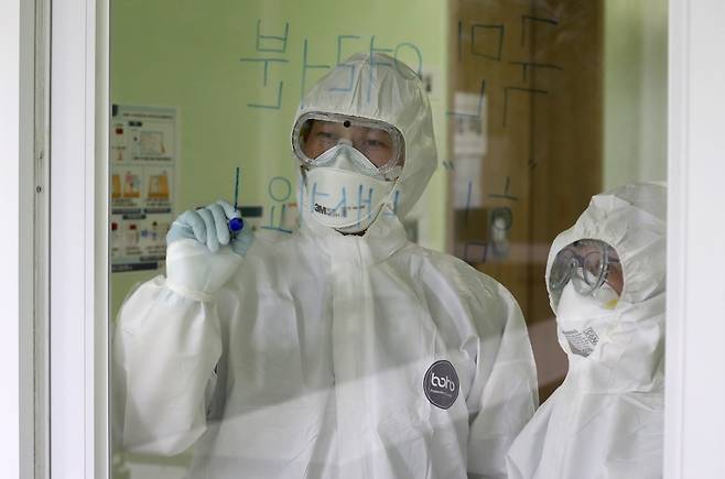 국민들에게 보내는 감사 김 과장과 안 과장이 격리 병동 투명 벽에 '여러분 힘내세요'를 적고 있다. 이 투명 격리병동과 일반병동 간 의료진이 소통하는 주요 창구였다.