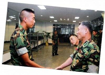 해병대 시절 상관과 악수하는 김원일. 해병대 트레이드마크인 돌격머리를 하고 있다. [사진 김원일]