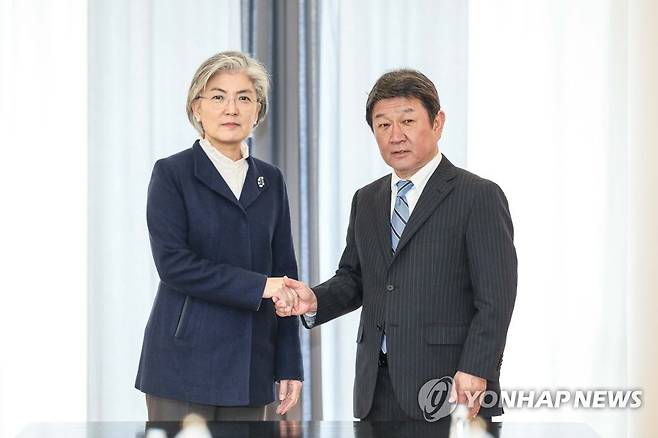 강경화(왼쪽) 한국 외교부 장관이 2020년 2월 15일(현지시간) 독일 뮌헨에서 한일 외교장관 회담을 앞두고 모테기 도시미쓰 일본 외무상의 손을 잡고 기념 촬영에 응하고 있다 [외교부 제공. 재판매 및 DB 금지]