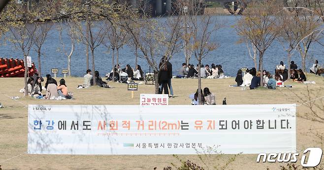정부가 국내 코로나19 신규 확진자가 지난주부터 하루 50명 내외로 감소하자 '사회적 거리두기'의 일정 성과가 있었다고 평가하면서도 재확산 방지 차원에서 사회적 거리두기 지속 실천을 강조하고 있다. 따뜻한 봄날씨를 보인 13일 오후 서울 여의도 한강공원을 찾은 시민들이 서로 거리를 두며 야외활동을 하고 있다. 2020.4.13/뉴스1 © News1 박지혜 기자