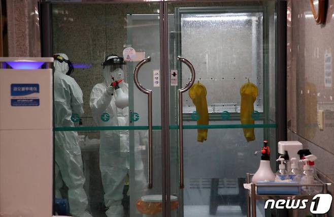 1일 부산 남구보건소 선별진료소에 마련된 '다목적 음압·양압 검체 채취 부스'에서 신종 코로나 바이러스 감염증 (코로나 19) 진단 검사를 마친 후 관계자가 부스 소독을 하고 있다. 2020.4.1/ 사진 = 뉴스 1