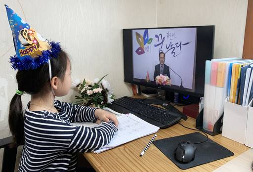 신종 코로나바이러스 감염증(코로나19) 확산 예방을 위한 초등학교 1~3학년 '온라인 개학'이 실시된 20일 오전 서울 종로구의 한 가정에서 1학년 어린이가 고깔모자를 쓴 채 온라인 입학식에 참여하고 있다. 뉴스1