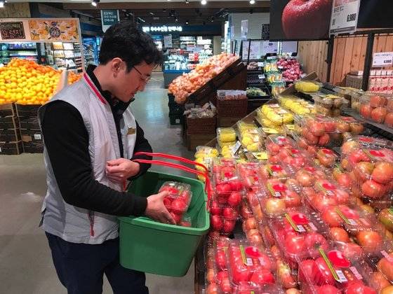 고객이 애플리케이션으로 주문한 토마토를 롯데마트 관계자가 담고 있다. 문희철 기자