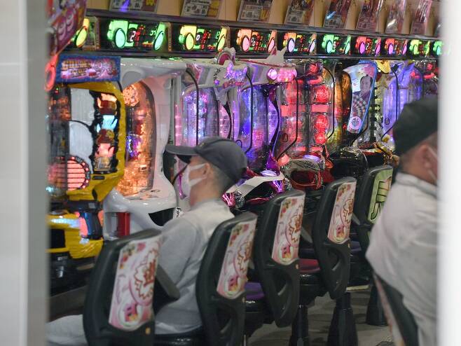 (오사카 교도=연합뉴스) 신종 코로나바이러스 감염증(코로나19)으로 긴급사태가 선포된 가운데 지난 8일 일본 오사카시의 한 파친코에서 마스크를 쓴 사람들이 게임을 하고 있다.