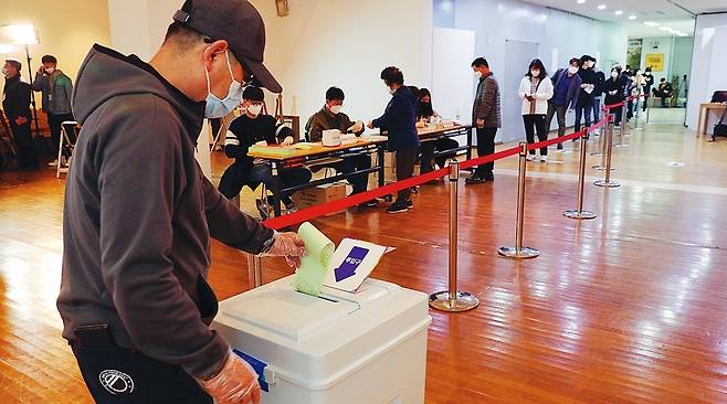 제21대 국회의원 선거일인 4월15일 오전 종로구 상명대학교 예술디자인대학원 로비 전시실에 마련된 이화동 제1 투표소에서 체온을 재고 손 소독을 마친 유권자들이 마스크를 쓰고 비닐장갑을 낀 채 투표하고 있다. 김봉규  선임기자 bong9@hani.co.kr