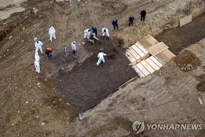 지난달 9일 뉴욕 동쪽 하트섬 무연고자 묘지에 시신을 집단 매장하는 모습 [로이터=연합뉴스 자료사진]