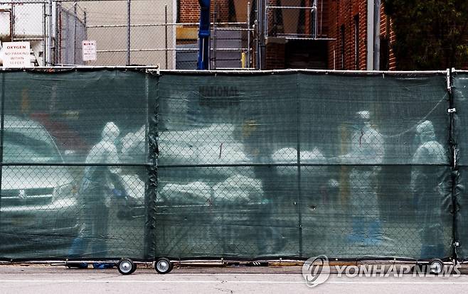20일 뉴욕 브루클린병원 밖에 설치된 임시 안치소로 옮겨지는 코로나19 사망자 시신 [EPA=연합뉴스]