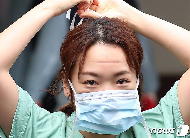 지난 2월 27일 오전 신종 코로나바이러스 감염증(코로나19) 지역거점병원인 계명대 대구동산병원에서 밤새도록 코로나19와 싸우며 확진자를 돌보고 나오는 의료진이 보호구를 벗고 마스크를 착용하는 순간 얼굴에 눌린 자국이 선명하게 남아 있다. 2020.2.27/뉴스1 © News1 공정식 기자