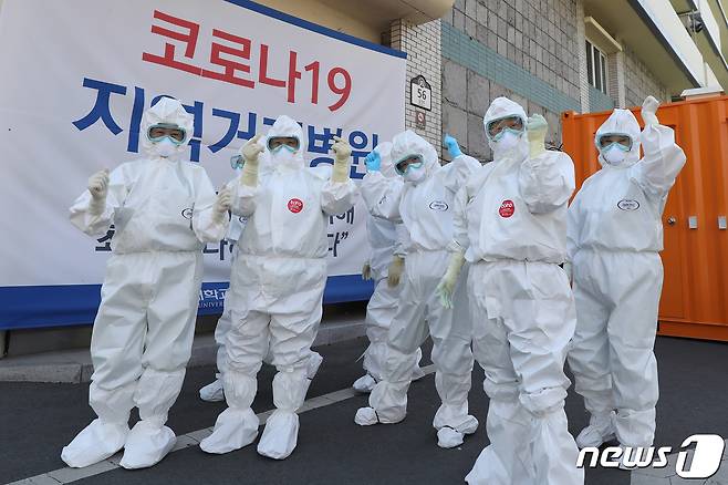 7일 오전 신종 코로나바이러스 감염증(코로나19) 지역거점병원인 대구 중구 계명대 대구동산병원에서 완치자 퇴원 후 격리병동 청소를 위해 보호복을 입은 병원 미화팀 관계자들이 파이팅을 외치고 있다. 이날 대구·경북 모두 코로나19 신규 환자가 나오지 않았다. 대구는 나흘째, 경북은 사흘 연속 신규 확진자 제로(0명) 상태다. 대구·경북에서 3~4일 연속 확진자 0명을 기록한 것은 첫 확진자가 나온 지난 2월 18일 이후 처음이다. 현재 대구동산병원에는 114명이 입원 치료를 받고 있다. 2020.5.7/뉴스1 © News1 공정식 기자