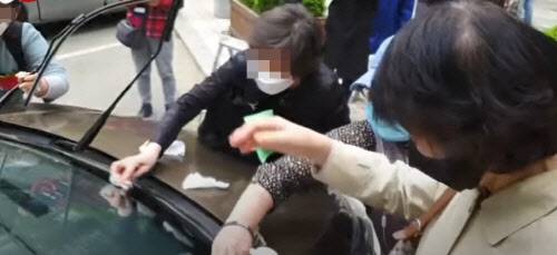 8일 오전 서울중앙지법에 모인 조국 전 법무부 장관의 지지자들이 조 전 장관의 차량에 쌓인 먼지를 물티슈로 닦아내고 있다. /유튜브 캡쳐