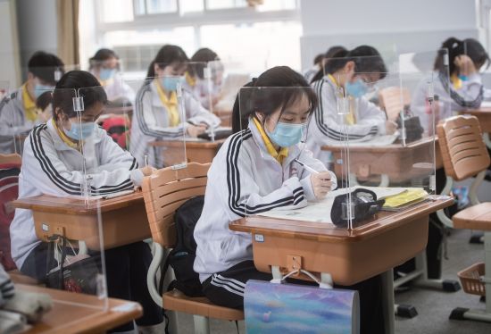 (우한 신화=연합뉴스) 6일 중국 후베이성 우한의 한 중학교에서 마스크를 착용한 학생들이 신종 코로나바이러스 감염증(코로나19) 예방을 위해 투명 가림막이 설치된 책상에 앉아 공부하고 있다.