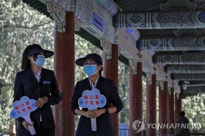 중국 베이징의 한 사원에서 "마스크를 착용하고, 모임을 금지한다"는 팻말을 든 직원 [AP=연합뉴스]