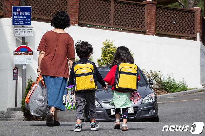 12일 서울 한 유치원에서 한 할머니가 두 손자 손녀를 긴급돌봄을 위해 등원시키고 있다./뉴스1 © News1 유승관 기자