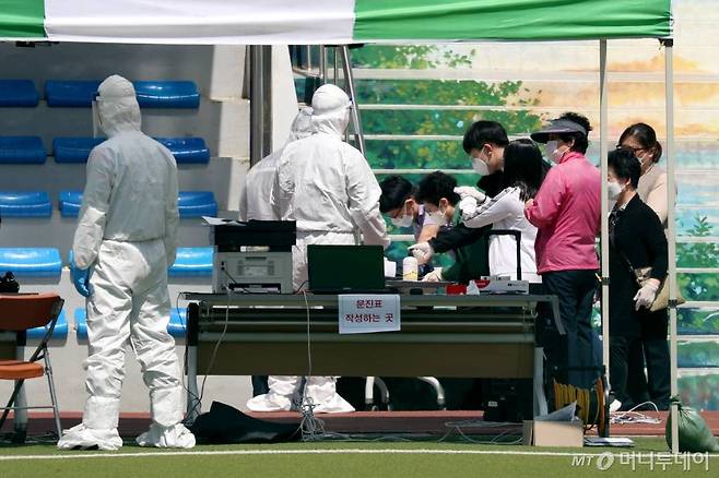 인천 지역에서 '서울 이태원 클럽발' 코로나19 확진자가 무더기로 발생한 가운데 13일 인천 미추홀구청에 마련된 코로나19 선별진료소를 찾은 주민들이 문진표를 작성하고 있다. / 사진=이기범 기자 leekb@