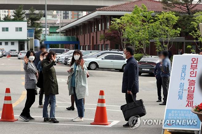 317만에 복직된 톨게이트 요금 수납원들 (용인=연합뉴스) 권준우 기자 = 14일 오전 도로공사 비정규직의 정규직 전환 과정에서 자회사 전환 방식에 반대해 해고됐던 톨게이트 요금 수납원들이 319일만에 복직돼 경기도 용인시 기흥구 한국도로공사 수원지사로 출근하며 취재진에 손을 흔들고 있다. 2020.5.14 stop@yna.co.kr