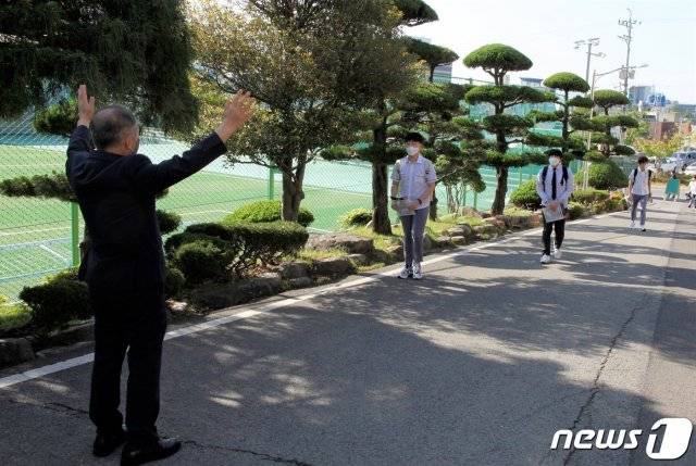 (순천=뉴스1) 고3 등교개학이 시작된 20일 오전 전남 순천매산고등학교에서 정은균 교장이 두팔을 벌려 등교하는 학생을 맞이하고 있다.2020.5.20/뉴스1