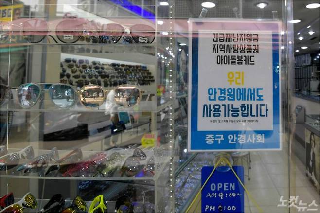 정부의 긴급재난지원금 사용이 가능해진 가운데 안경점에 재난지원금 사용 가능 안내문이 붙어있다. (사진=박종민 기자/자료사진)