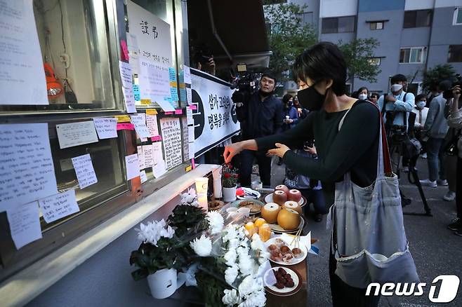 서울 강북구의 한 아파트에서 주민에게 지속적인 괴롭힘과 폭행을 당했다고 주장하는 경비원이 스스로 목숨을 끊는 사건이 발생했다. 11일 오후 해당 아파트 경비실 앞에 차려진 분향소에서 주민들이 촛불집회를 하며 애도하고 있다. 2020.5.11/뉴스1 © News1 임세영 기자